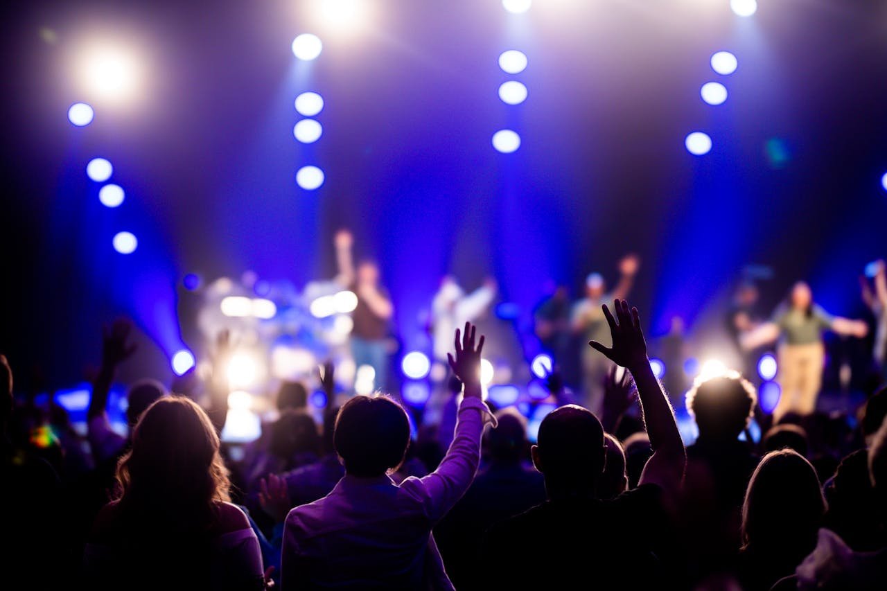 A vibrant concert scene with an engaged audience enjoying live music under dramatic lighting.