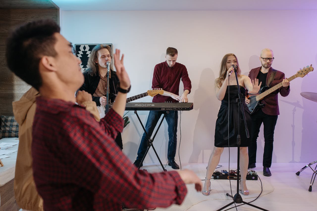A lively indoor concert with a band performing on stage in front of an audience.
